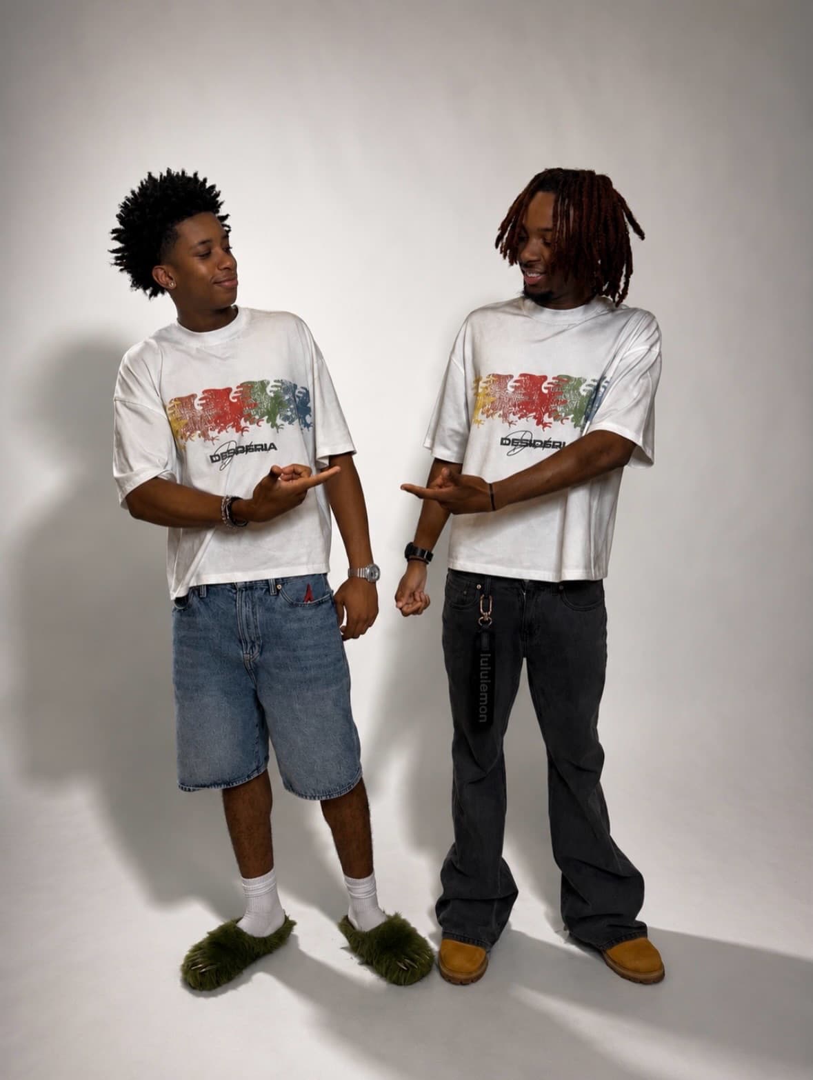 Two models in the multicolor eagle tee pointing at each other in studio